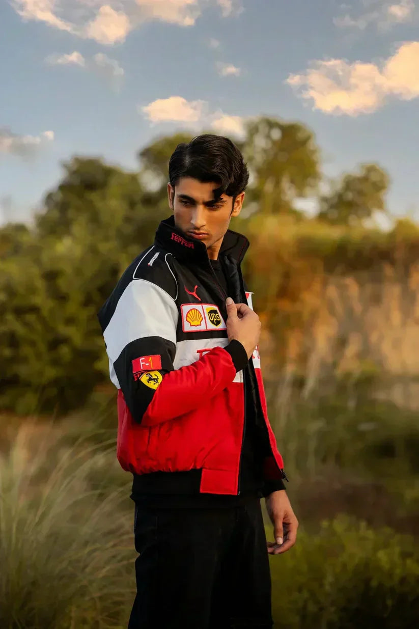 Person wearing a red, black, and white Ferrari jacket with logos outdoors