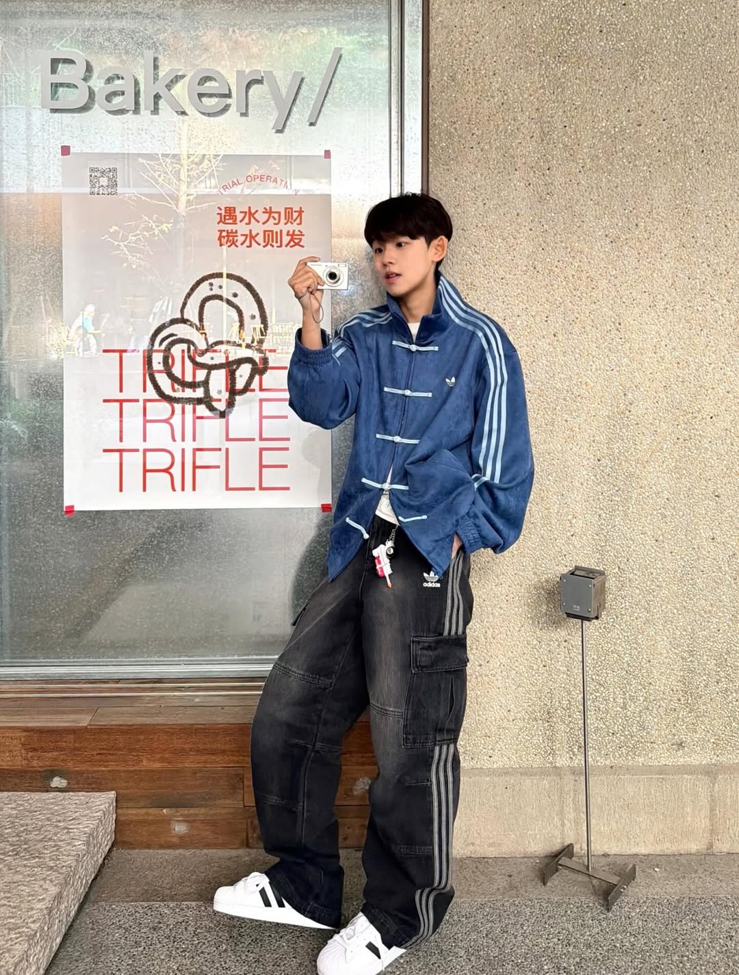 Person wearing a Northly Navy Blue CNY Jacket with white stripes in front of a bakery door.