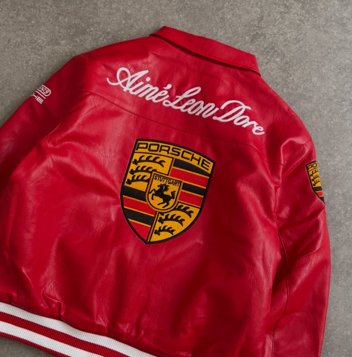 Close-up of racing patches on red motorsport Porsche leather jacket for men
