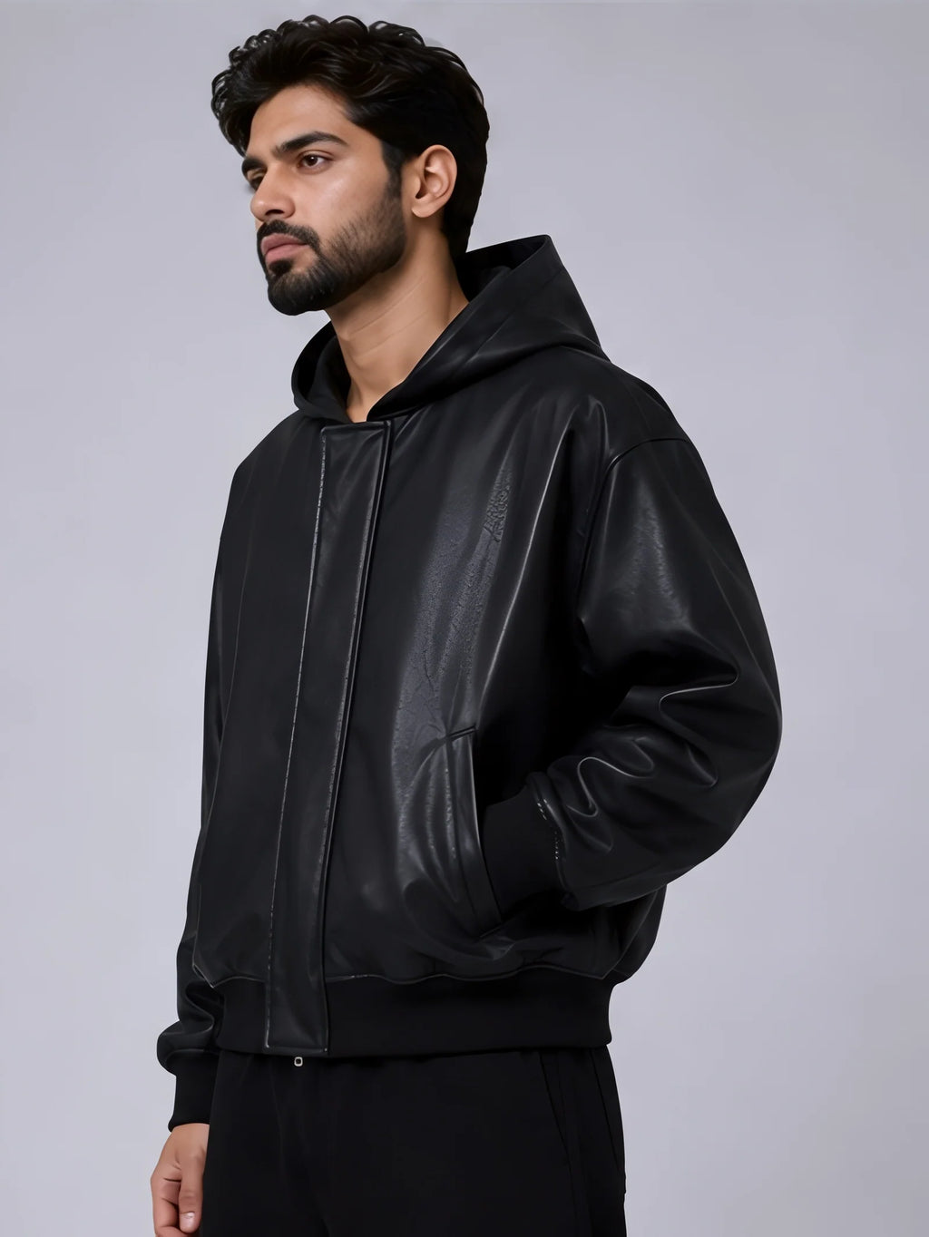 Man wearing a black leather jacket on a gray background