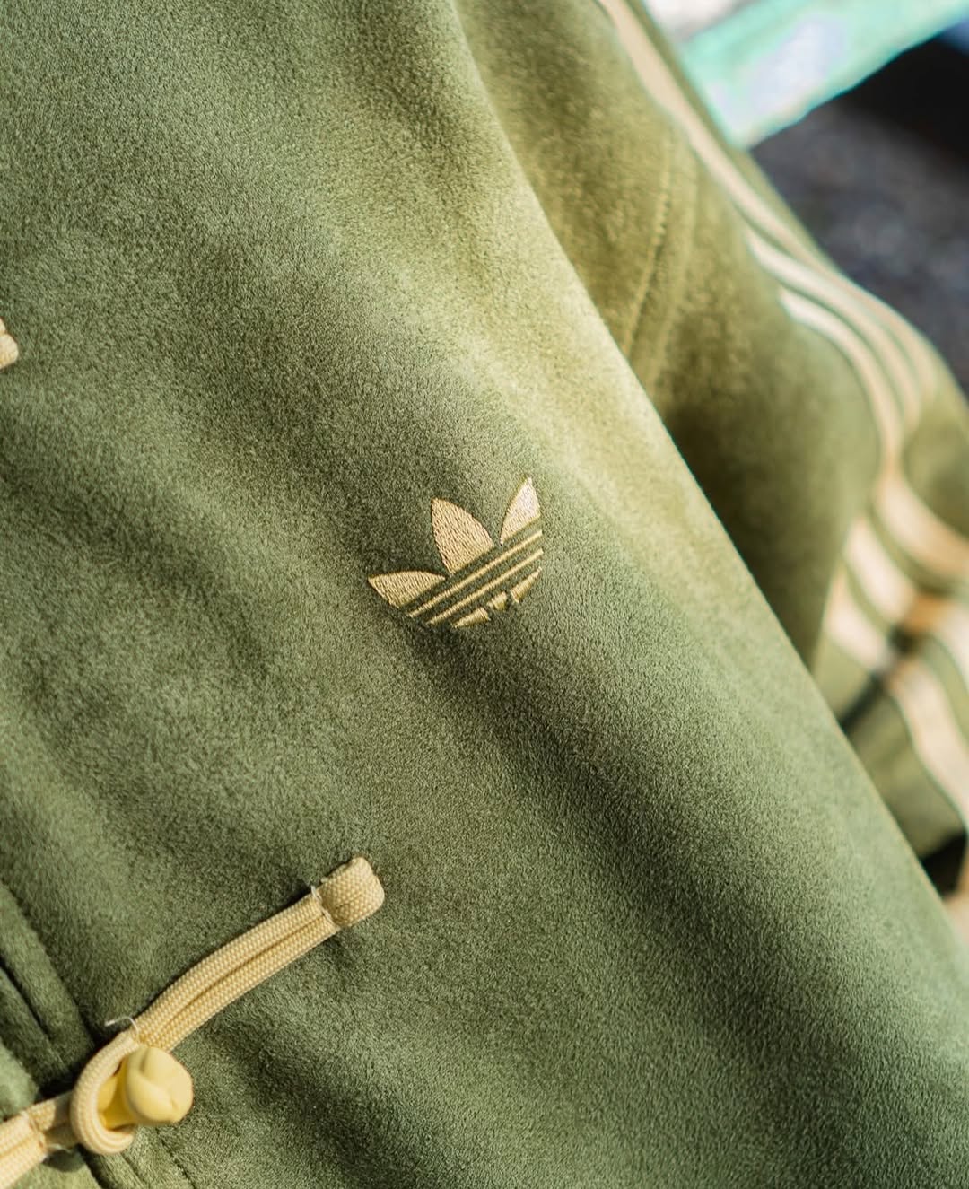 Close-up of traditional Chinese knot closures on the premium olive green Northly Tang jacket for women